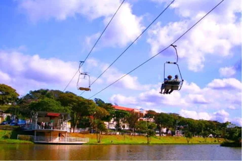 Teleférico de Atibaia no Lago do Major com duas pessoas atravessando.