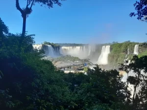 O que fazer em Foz do Iguaçu em 3 dias: Vista panorâmica das Cataratas do Iguaçu com passarela de observação e visitantes admirando as quedas d’água. Foto: arquivo pessoal.