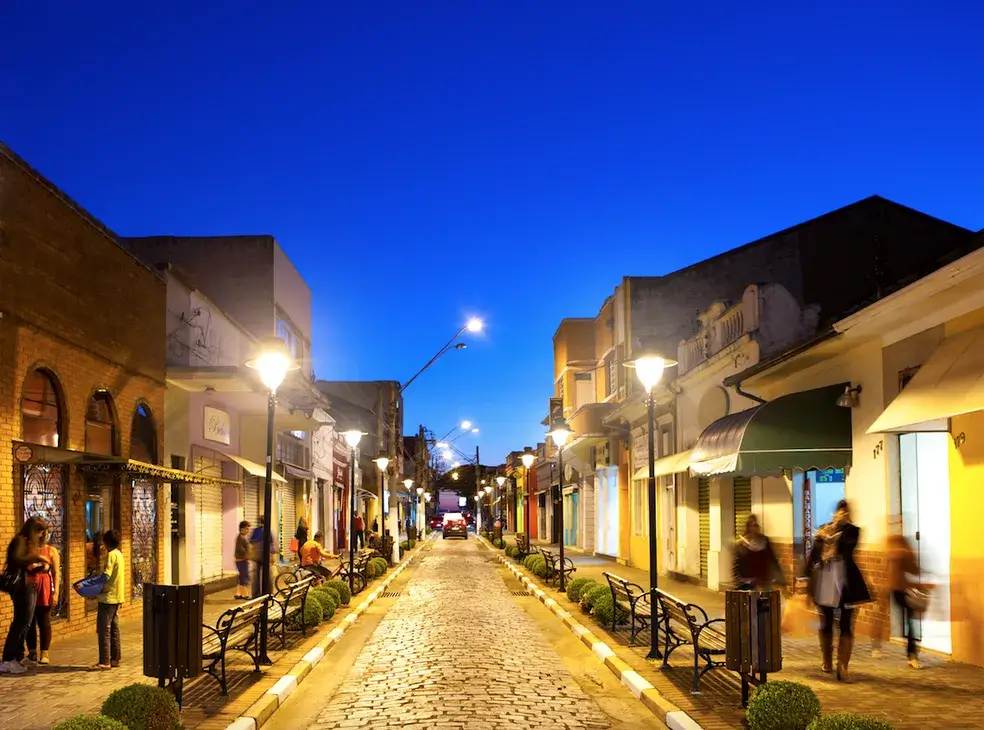 Rua do centro histórico de Atibaia ao anoitecer, com destaque para a arquitetura colonial dos comércios.