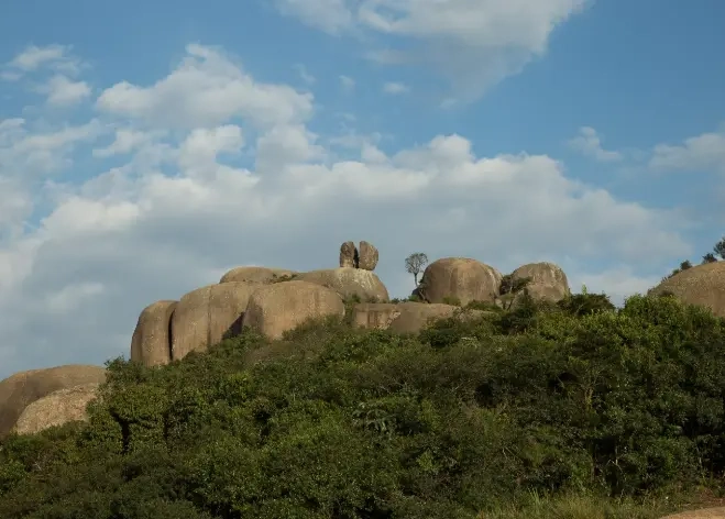 Pedra Grande em Atibaia vista de baixo, com árvores à frente.