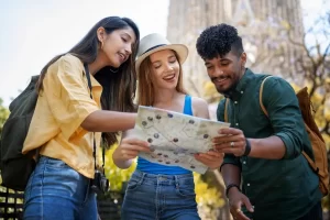 Três pessoas escolhendo um roteiro de viagem a partir de um mapa impresso, representando a escolha do que fazer em Atibaia em um dia ou em dois dias. Fonte: Freepik.