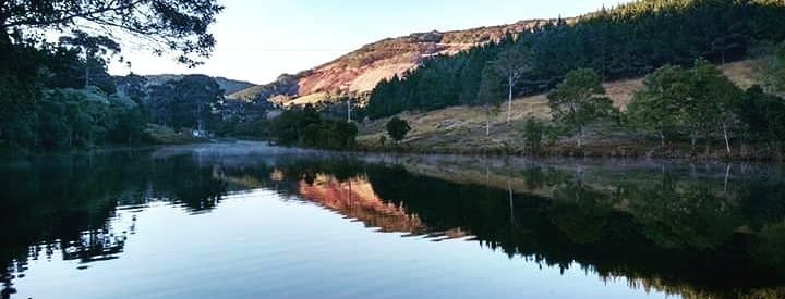 Vista da Reserva Ecológica do Vuna em Atibaia, com a represa à frente e as montanhas atrás.