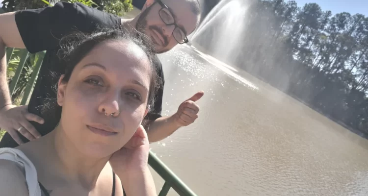 O que fazer em Indaiatuba foto da entrada do Museu da Água, com um chafariz ao fundo e à frente o casal Marcia Lira, Redatora do blog Viagens e Passeios, e Windsor, analista SEO do Viagens e Passeios.