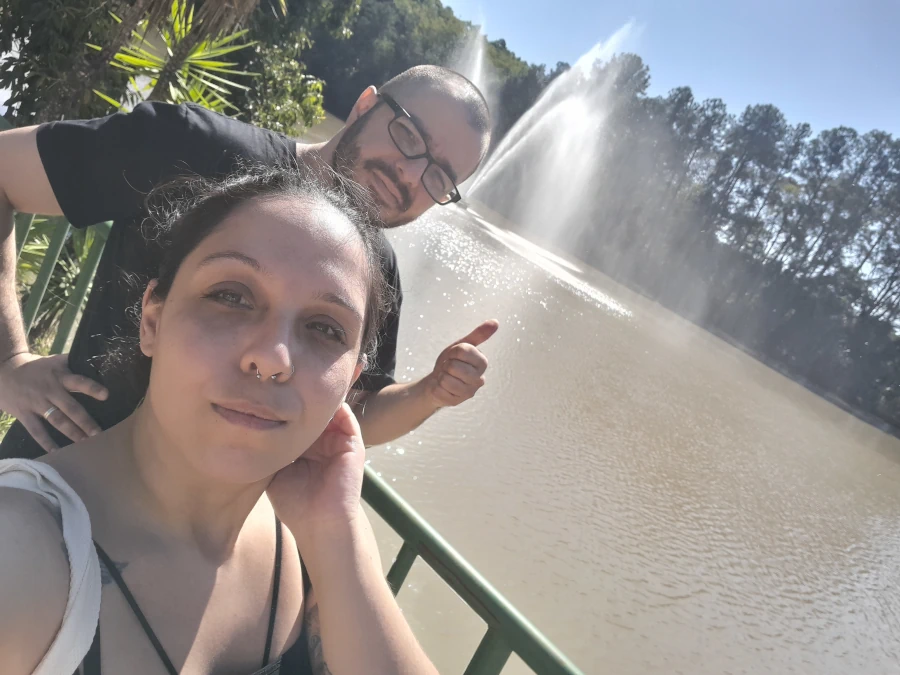 O que fazer em Indaiatuba foto da entrada do Museu da Água, com um chafariz ao fundo e à frente o casal Marcia Lira, Redatora do blog Viagens e Passeios, e Windsor, analista SEO do Viagens e Passeios.