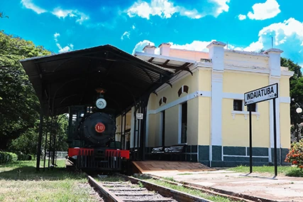 Fachada amarela do Museu Ferroviário de Indaiatuba com locomotiva histórica na plataforma.