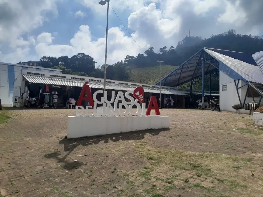 Praça do Artesão em Águas de Lindóia, com estandes de artesanato e o letreiro turístico da cidade em destaque.
