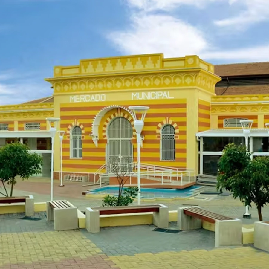 Fachada amarela e laranja do histórico Mercado Municipal de Amparo, um dos principais pontos turísticos da cidade.