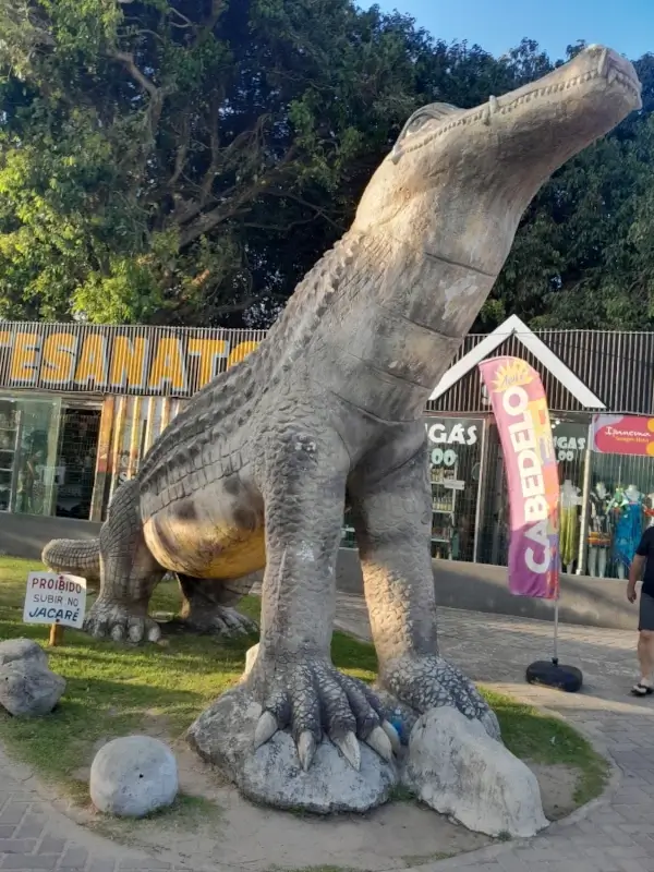 Estátua grande de um jacaré localizada em frente a lojas de artesanato na Praia do Jacaré, em Cabedelo, região metropolitana de João Pessoa.
