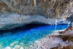 Foto de uma gruta na região de Bonito (MS). A água é azul cristalina e o teto da gruta possui Estalactites.
