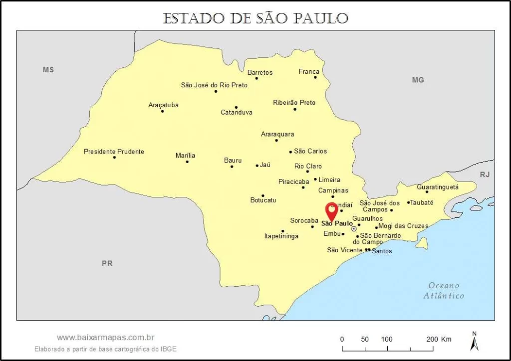 Mapa político do Estado de São Paulo com destaque para a localização da cidade de São Paulo, sinalizada por um marcador vermelho. O mapa mostra as principais cidades do interior, como Campinas e Ribeirão Preto, as regiões vizinhas (PR, MS, MG, RJ) e o Oceano Atlântico, além de uma escala gráfica e rosa dos ventos.