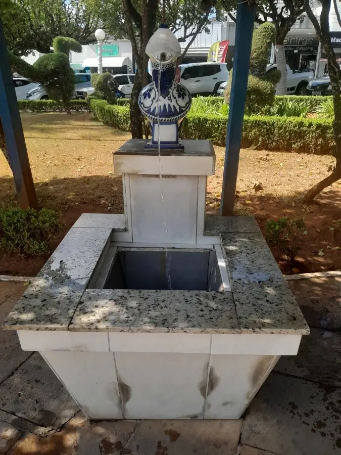 Fonte pública de água na praça de Monte Sião decorada com um vaso de porcelana artesanal pintado com padrões tradicionais em azul e branco.